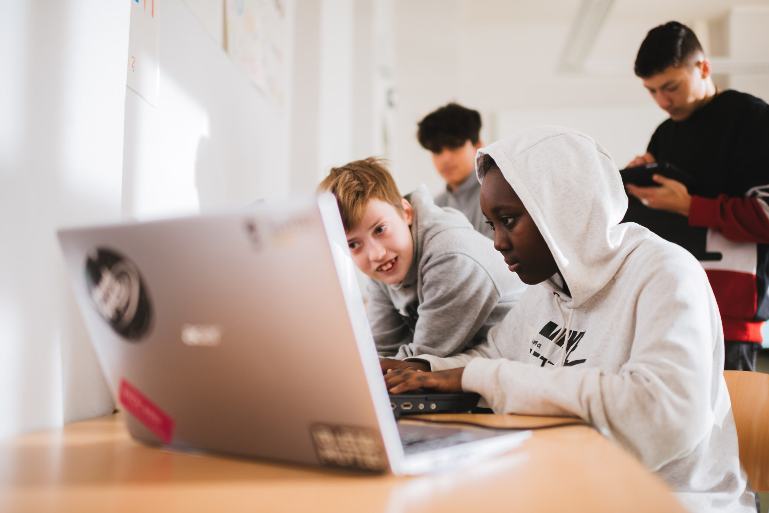 Gruppe von Jugendlichen arbeitet an einem Laptop